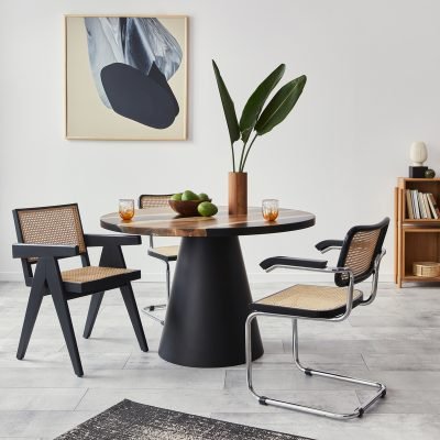 Stylish composition of dining room interior with design table, modern chairs, decoration, tropical leaf in vase, fruits, bookcase, abstract mock up paintings and elegant accessories in home decor.